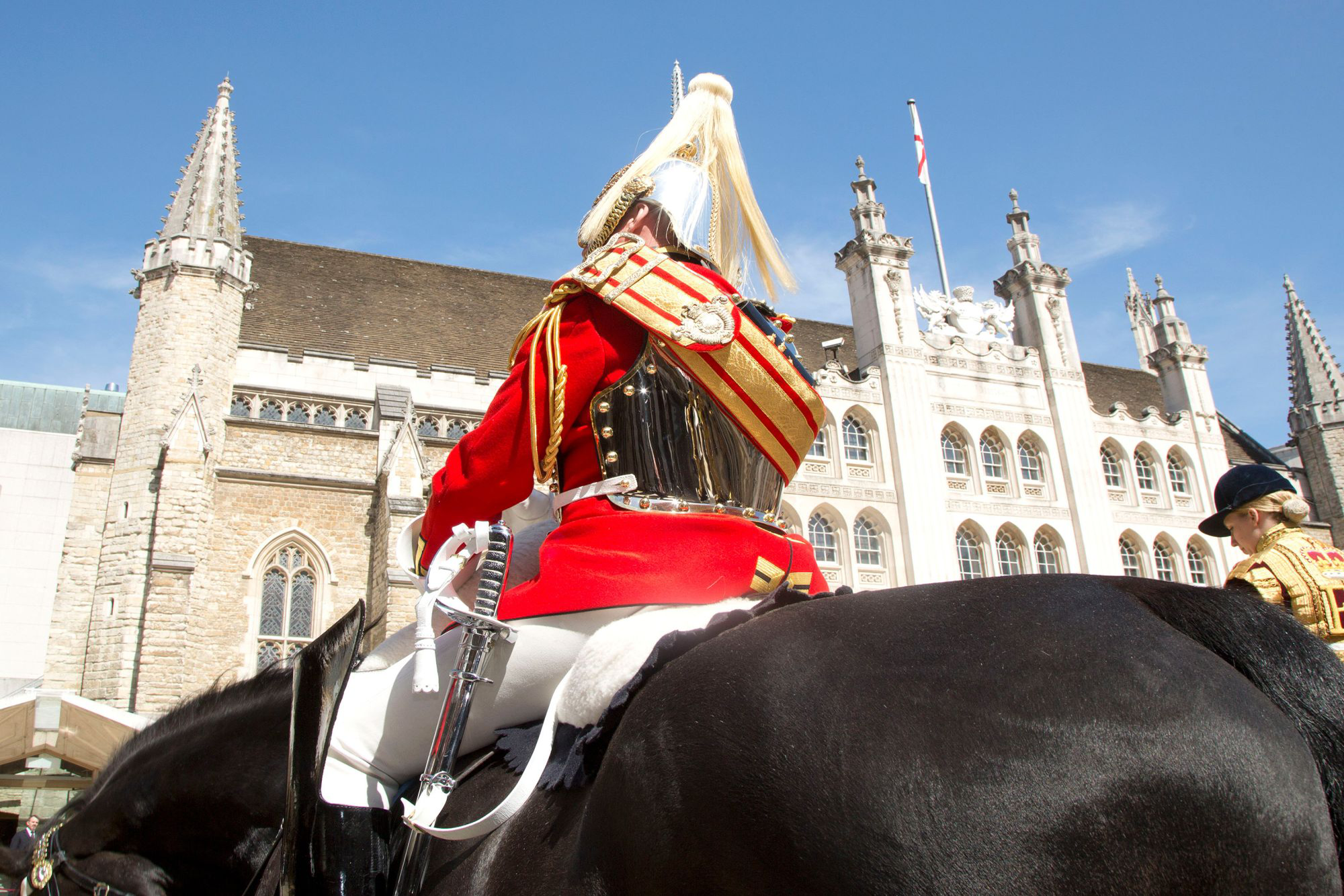 Royal Guard dressed in uniform, riding a black horse outside The Guildhall