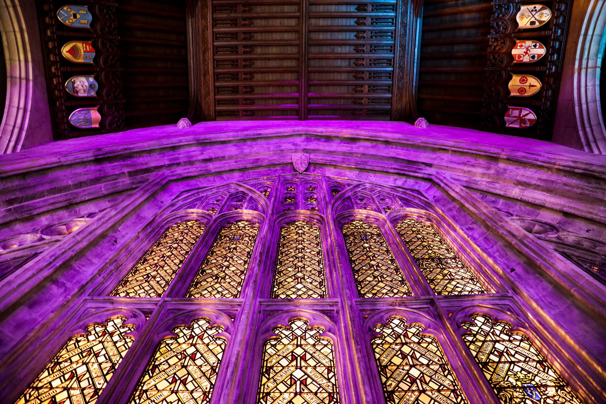 Looking up at the stainglass windows inside the great hall with purple lighing